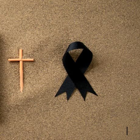 Cruz de luto con cinta de duelo en la rena